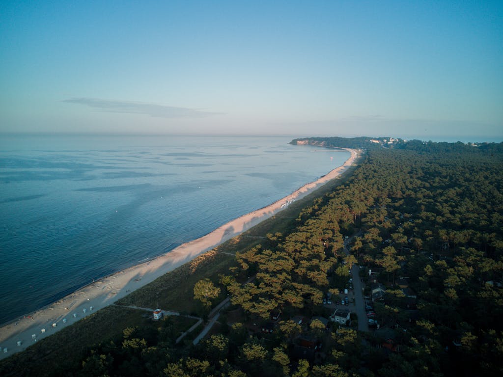 A stunning aerial view of Usedom Island's coastline with a forest and beach at sunrise, capturing nature's tranquility.